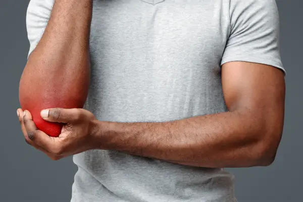 Golfer supporting his arm where golfer's elbow hurts