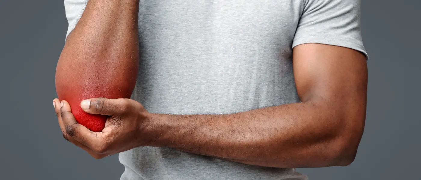 Golfer supporting his arm with the inside of the elbow highlighted, where golfer's elbow hurts