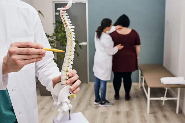 Chiropractor explaining treatment options using a model of the spine