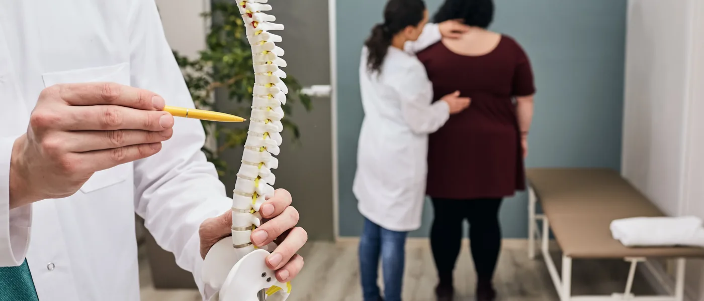 Chiropractor explaining treatment options using a model of the spine