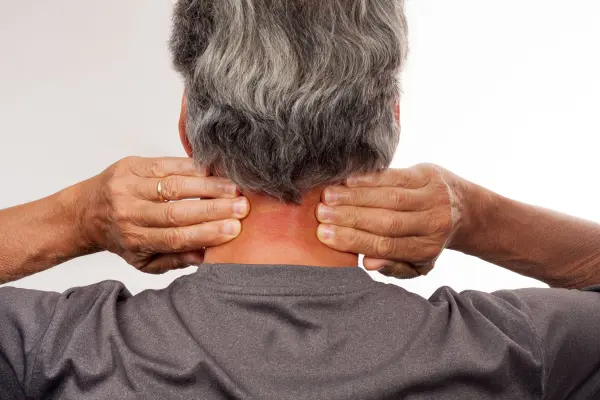 Man holding the back of his neck where a pinched nerve is felt