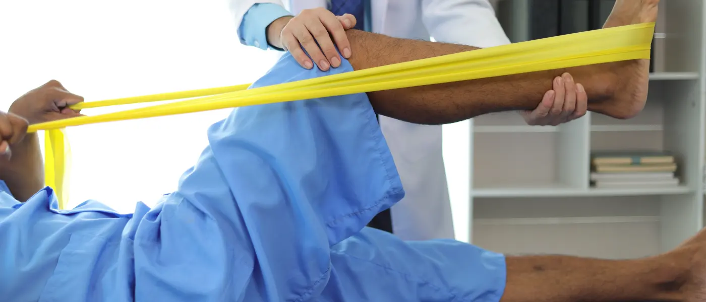 Clinician guiding a patient through a supported straight leg raise on a treatment table