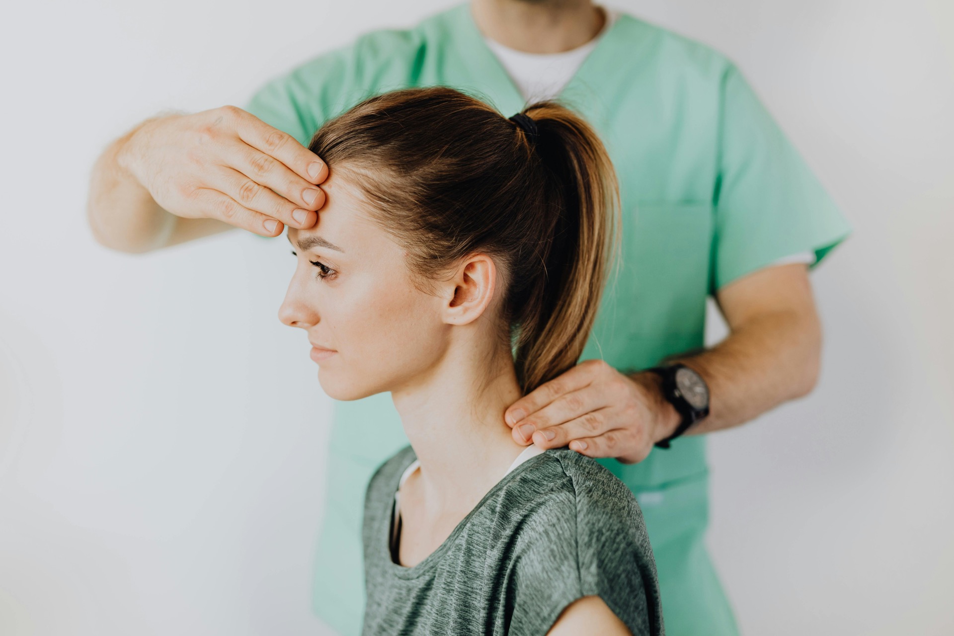 Chiropractor performing a cervical and postural assessment on a patient